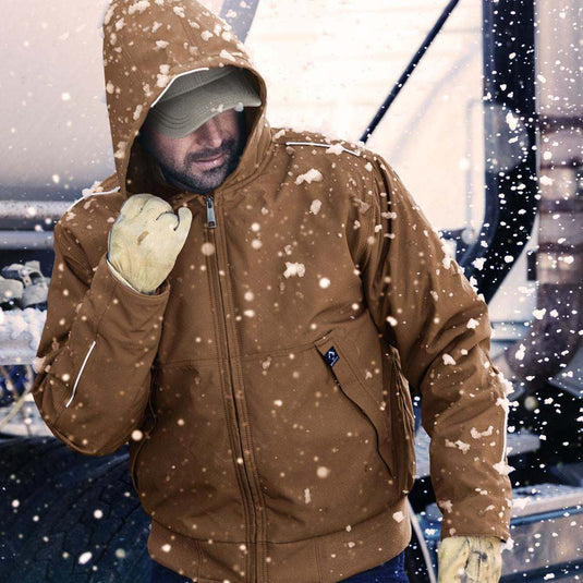 Man wearing saddle Rubicon jacket standing outside working in the snow.