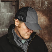 Man wearing charcoal Range Trucker Hat looking to the side