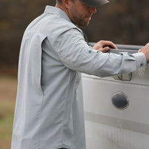 Man wearing grey Crossroad Long Sleeve shirt while closing truck bed