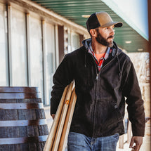 Man wearing black Laredo carrying wood on a jobsite