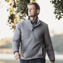 Man wearing grey Keystone jacket walking outside.
