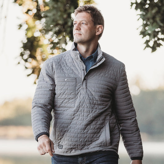 Man wearing grey Keystone jacket walking outside