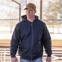 Man wearing Navy Crossfire Zip Up Hoodie walking outside at baseball park