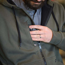 Man wearing Fatigue Bateman while putting away phone in chest pocket