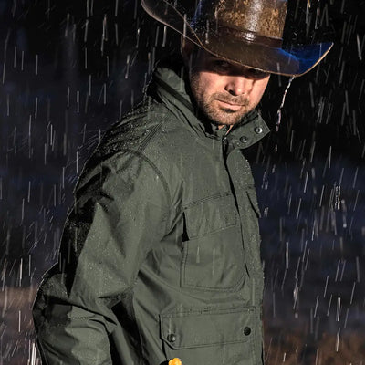 Customer wearing the DRI DUCK Field Jacket in rainy weather, showing its water-resistant features.