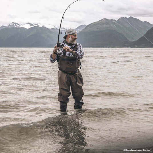 Man wearing navy and field khaki plaid Westwood Plaid Shirt while fishing outside.