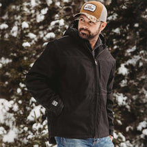 Man wearing black Kodiak Work Jacket while working outside.